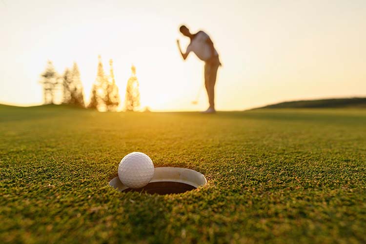 golf ball going into hole